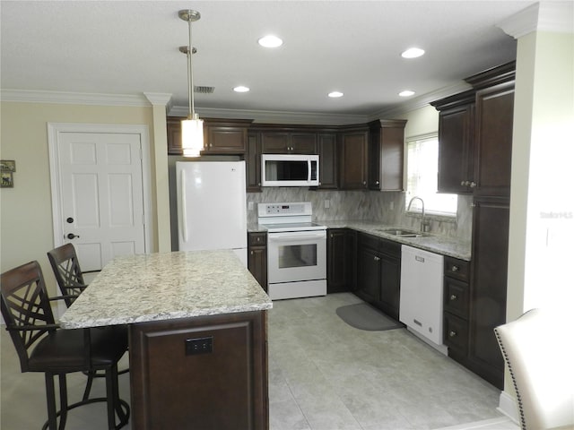 kitchen featuring pendant lighting, sink, a kitchen breakfast bar, crown molding, and white appliances