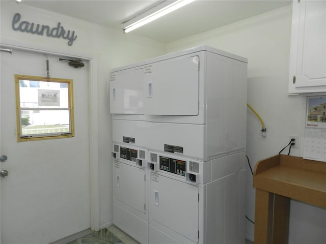 clothes washing area featuring stacked washer / drying machine and electric panel