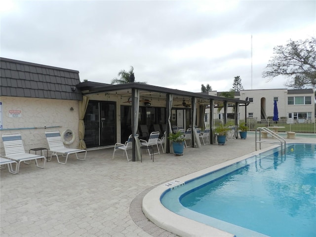 view of pool featuring ceiling fan and a patio area