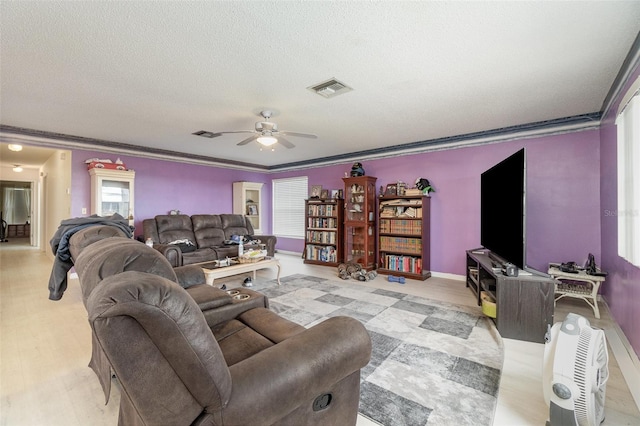 living room with crown molding, light wood-type flooring, a textured ceiling, and ceiling fan