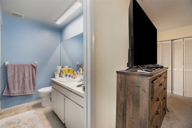 bathroom featuring toilet, tile patterned floors, and vanity