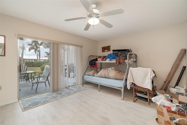 bedroom featuring access to exterior, ceiling fan, light hardwood / wood-style flooring, and a textured ceiling