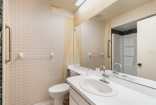 bathroom with visible vents, vanity, toilet, and wallpapered walls