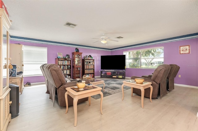 living area with visible vents, ceiling fan, light wood-style flooring, and baseboards