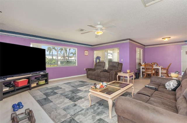 living room featuring baseboards, visible vents, a textured ceiling, and ornamental molding