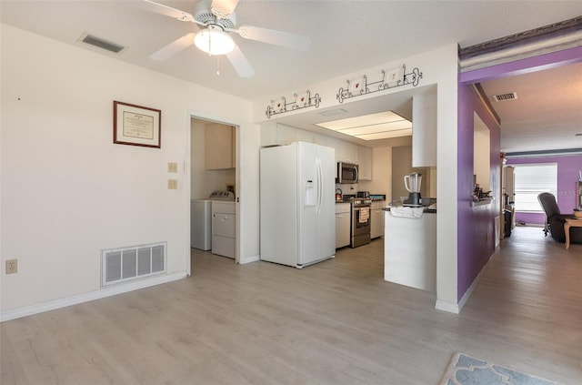 kitchen featuring separate washer and dryer, appliances with stainless steel finishes, light wood-type flooring, and visible vents