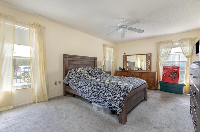 carpeted bedroom with a textured ceiling, ceiling fan, and baseboards