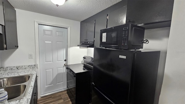 kitchen featuring dark wood-type flooring, sink, a textured ceiling, and black appliances