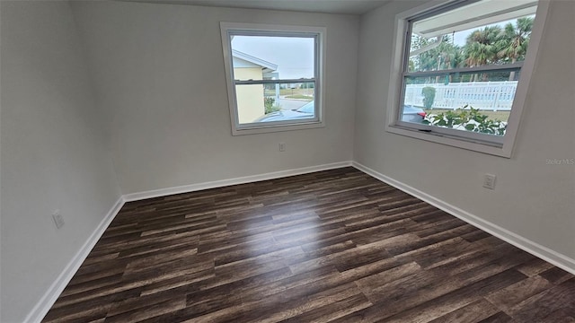 empty room featuring dark wood-type flooring and plenty of natural light