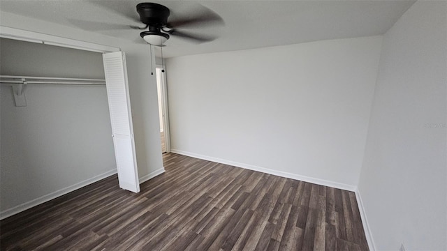 unfurnished bedroom featuring dark wood-type flooring, a closet, and ceiling fan