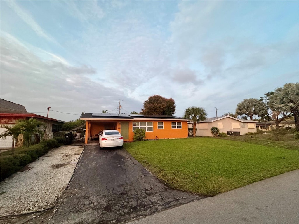 view of front of house with a garage, solar panels, and a front yard