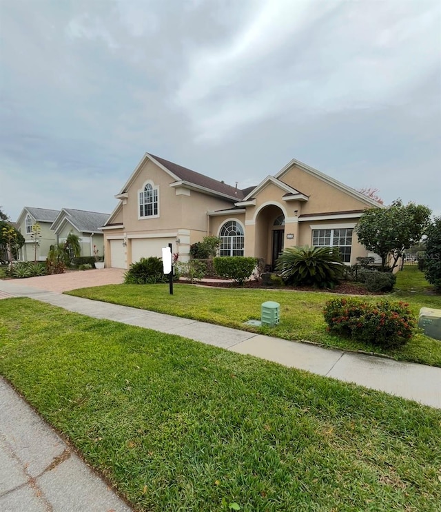 single story home with a garage and a front lawn