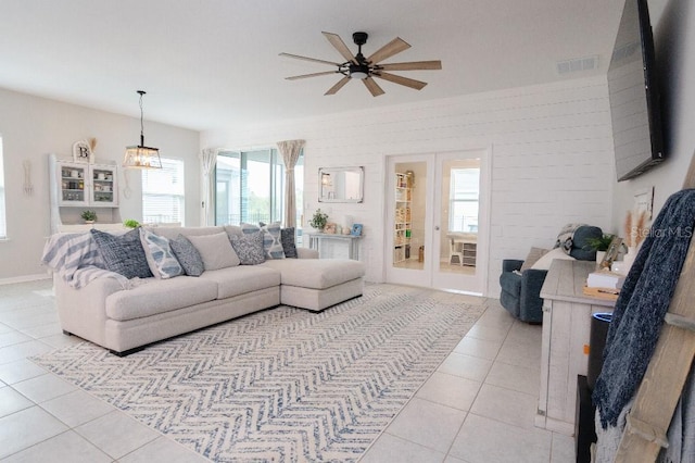 living room featuring brick wall, light tile patterned floors, and ceiling fan