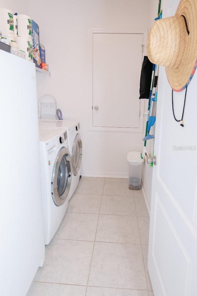 laundry area with light tile patterned flooring and washer and dryer