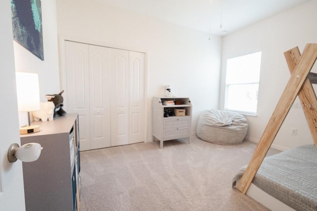 bedroom featuring light carpet and a closet