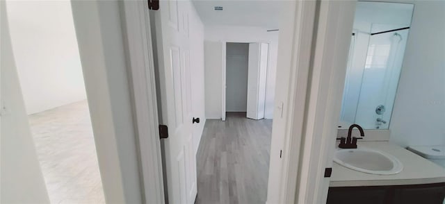 bathroom with vanity, hardwood / wood-style flooring, a shower, and toilet