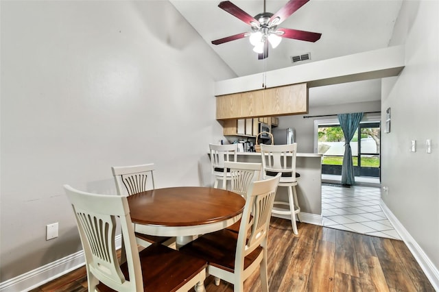 dining room with ceiling fan, dark wood-type flooring, and lofted ceiling