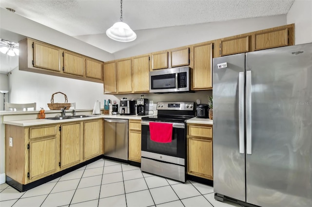 kitchen featuring pendant lighting, appliances with stainless steel finishes, sink, light tile patterned floors, and lofted ceiling