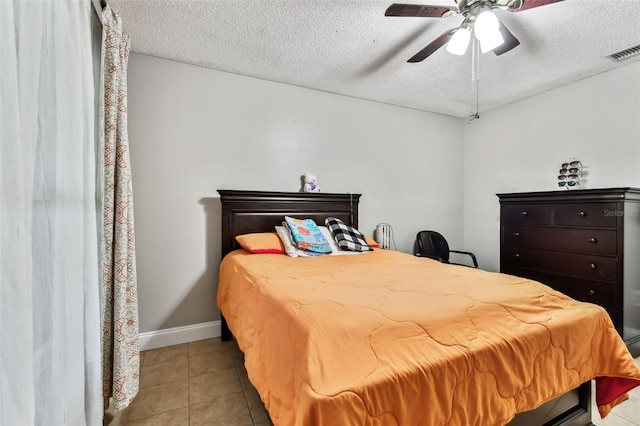 tiled bedroom featuring a textured ceiling and ceiling fan