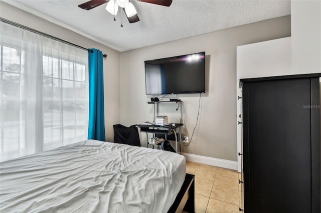 bedroom with ceiling fan, a textured ceiling, and light tile patterned flooring