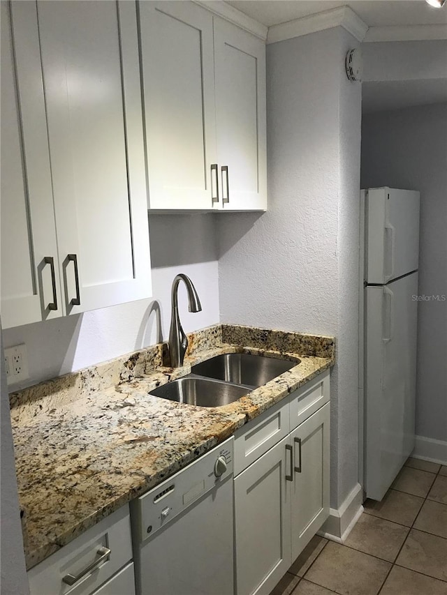 kitchen with dark stone countertops, sink, white appliances, and white cabinets