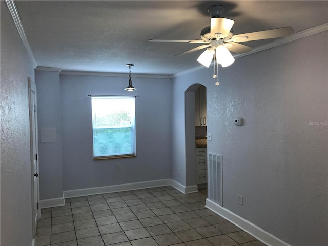 empty room featuring tile patterned flooring, ornamental molding, and ceiling fan