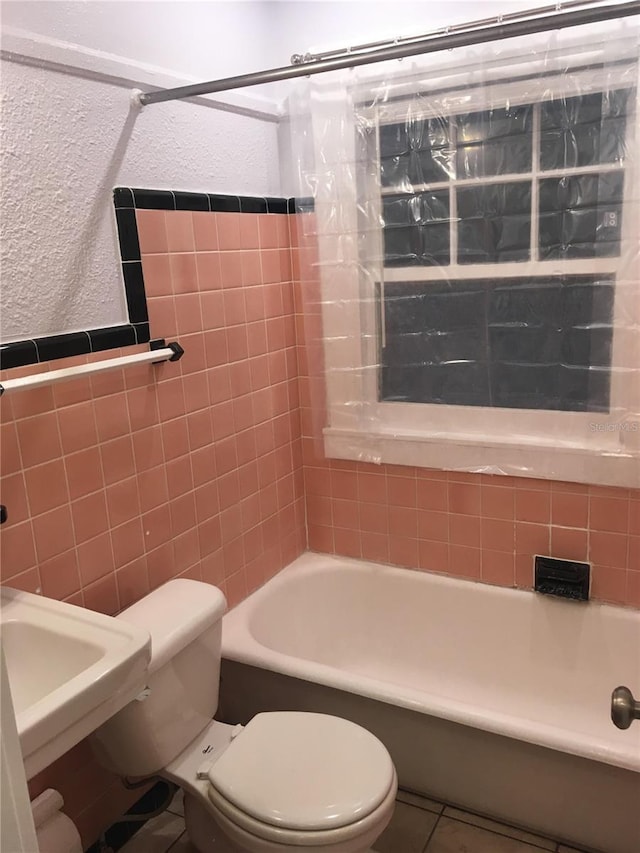 bathroom featuring shower / tub combo, toilet, and tile patterned flooring