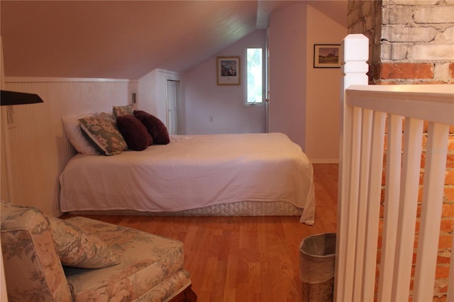 bedroom with lofted ceiling and light hardwood / wood-style floors