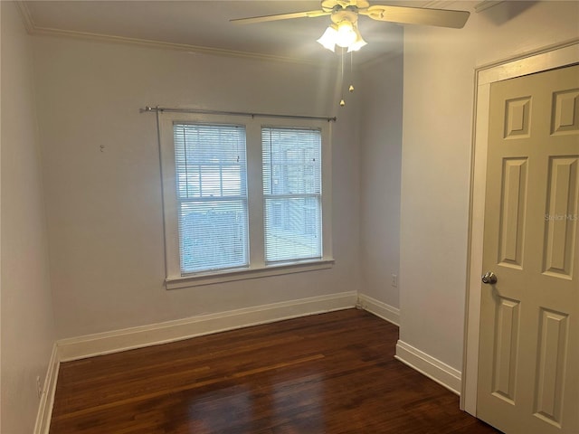 empty room with ornamental molding, dark wood-type flooring, a wealth of natural light, and ceiling fan