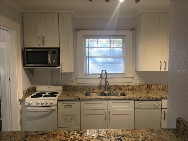 kitchen with light stone counters, sink, white appliances, and white cabinets