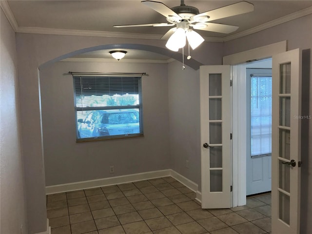 tiled spare room featuring ornamental molding, french doors, and ceiling fan