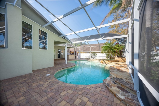 view of swimming pool with a patio area and glass enclosure