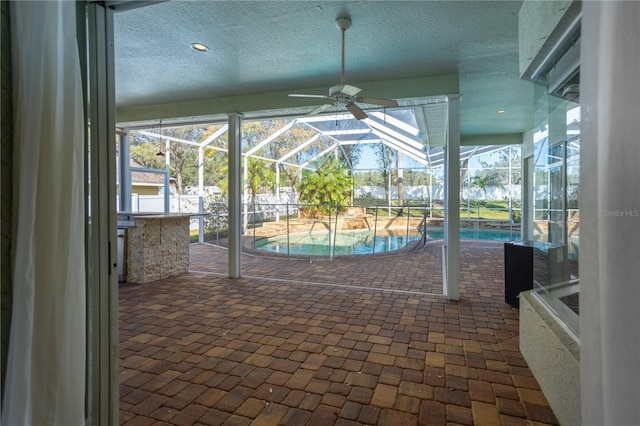 unfurnished sunroom with ceiling fan