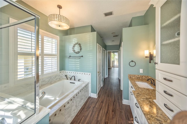 bathroom with vanity, hardwood / wood-style floors, a textured ceiling, and separate shower and tub