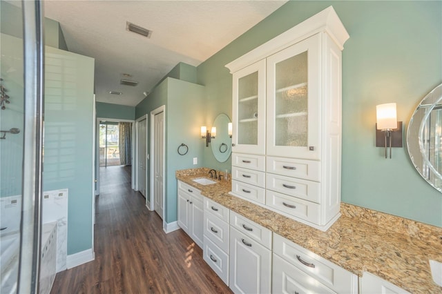 bathroom featuring vanity, hardwood / wood-style flooring, and a textured ceiling