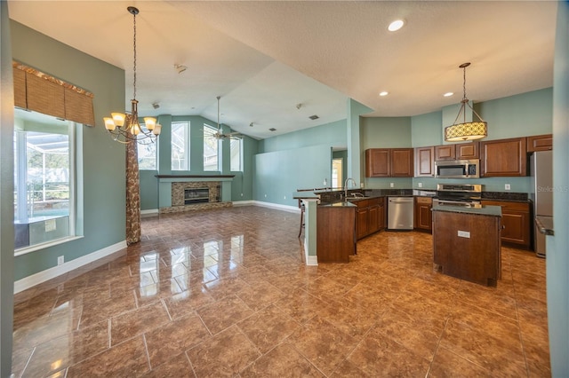 kitchen with pendant lighting, appliances with stainless steel finishes, vaulted ceiling, and a wealth of natural light