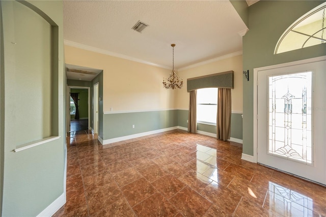 interior space with an inviting chandelier, ornamental molding, and a textured ceiling