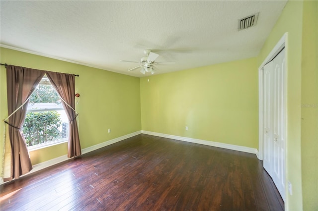 unfurnished room featuring a textured ceiling, dark wood-type flooring, and ceiling fan