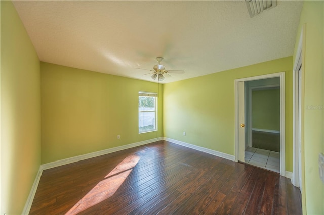 unfurnished room with dark hardwood / wood-style floors, a textured ceiling, and ceiling fan