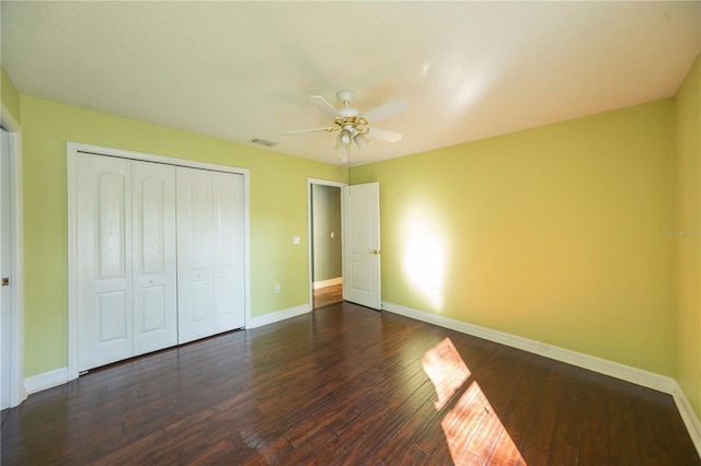 unfurnished bedroom with dark hardwood / wood-style floors, ceiling fan, and a closet