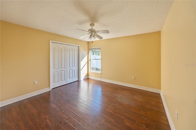 unfurnished bedroom with ceiling fan, dark hardwood / wood-style floors, a closet, and a textured ceiling