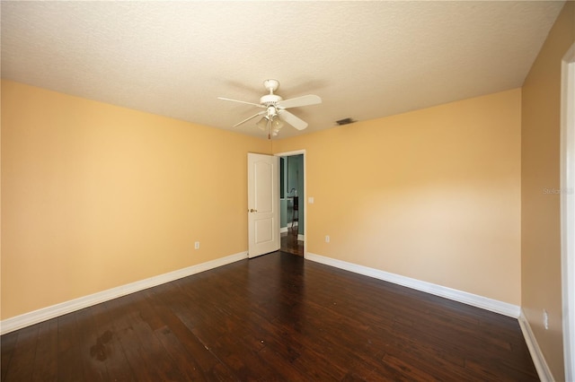 unfurnished room featuring dark wood-type flooring, a textured ceiling, and ceiling fan