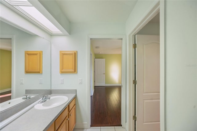 bathroom featuring vanity, a skylight, and tile patterned floors