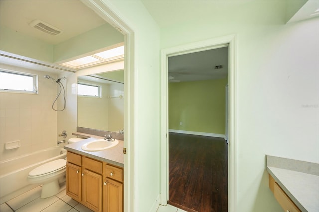 full bathroom featuring tiled shower / bath combo, vanity, tile patterned floors, and toilet