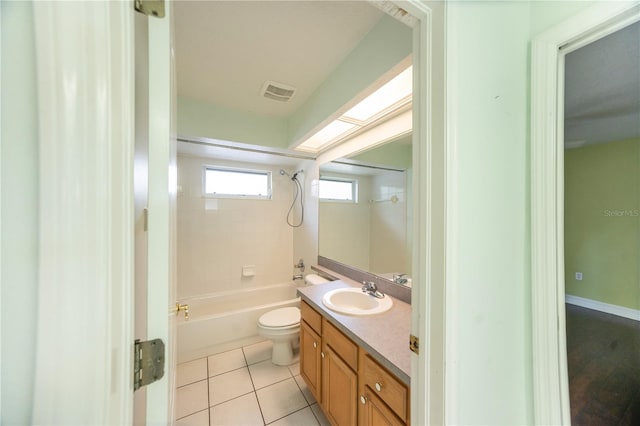 full bathroom with vanity, tiled shower / bath combo, tile patterned floors, and toilet