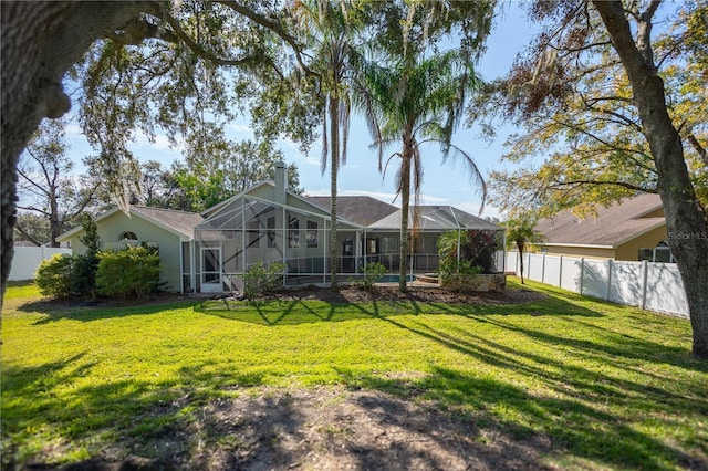 back of property with a lawn and glass enclosure