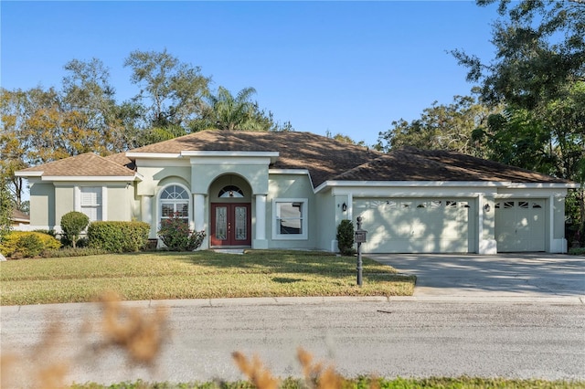 view of front of home featuring a garage, a front yard, and french doors