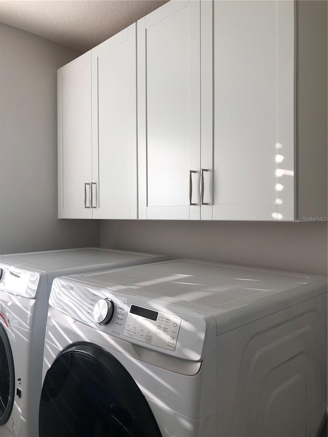 laundry area featuring cabinets and washing machine and dryer