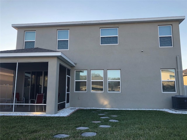 back of house with a sunroom, a lawn, and cooling unit