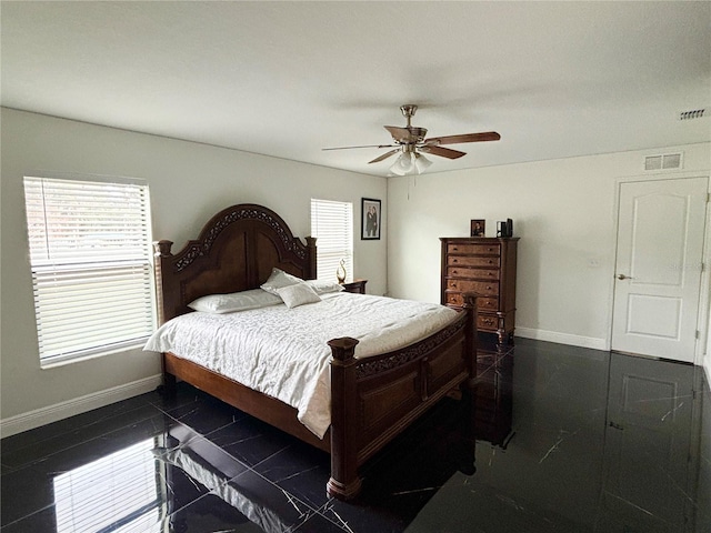 bedroom with ceiling fan and multiple windows